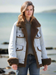 Woman_wearing_a_light-colored_jacket_with_brown_fur_trim_outdoors